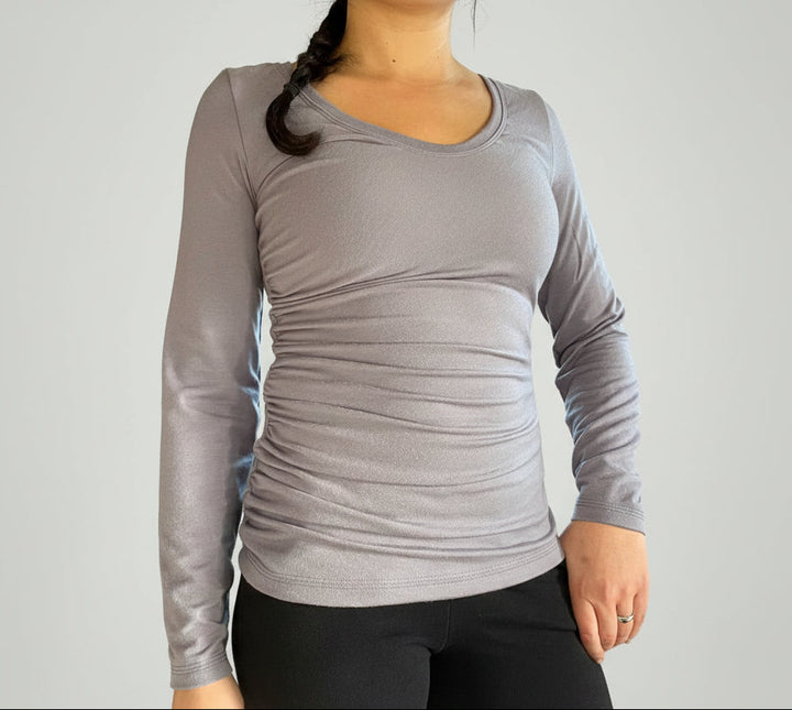 Person wearing a gray long-sleeve shirt in an indoor setting